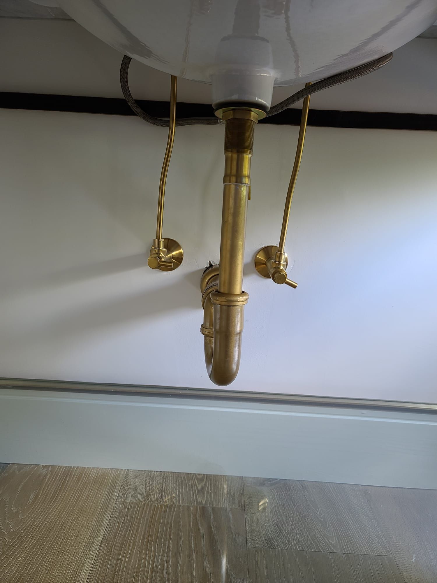 Ceiling-mounted pull-cord light fixture with brass fittings and two gold chains
