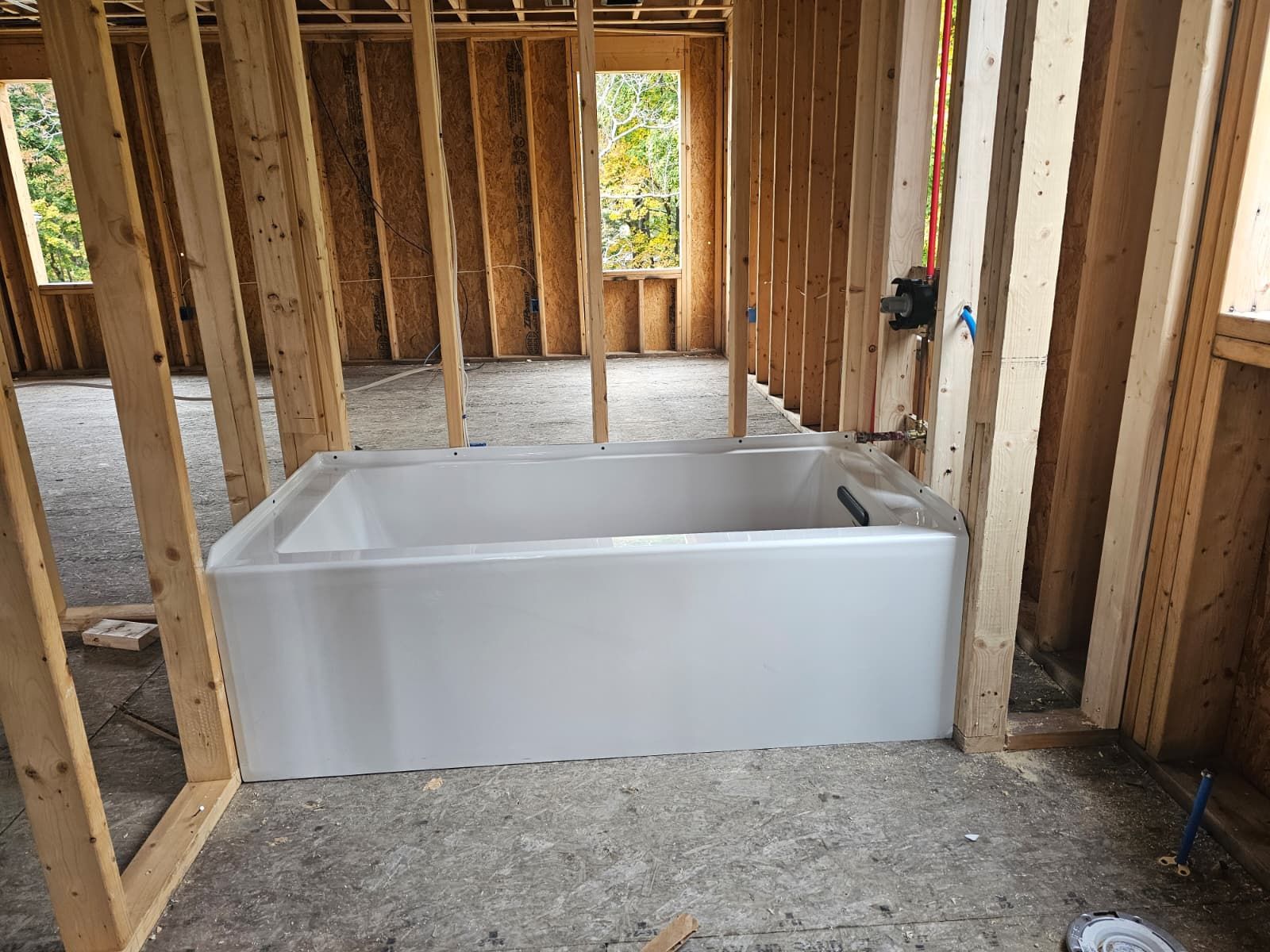 Bathtub installed in an unfinished framed bathroom under construction