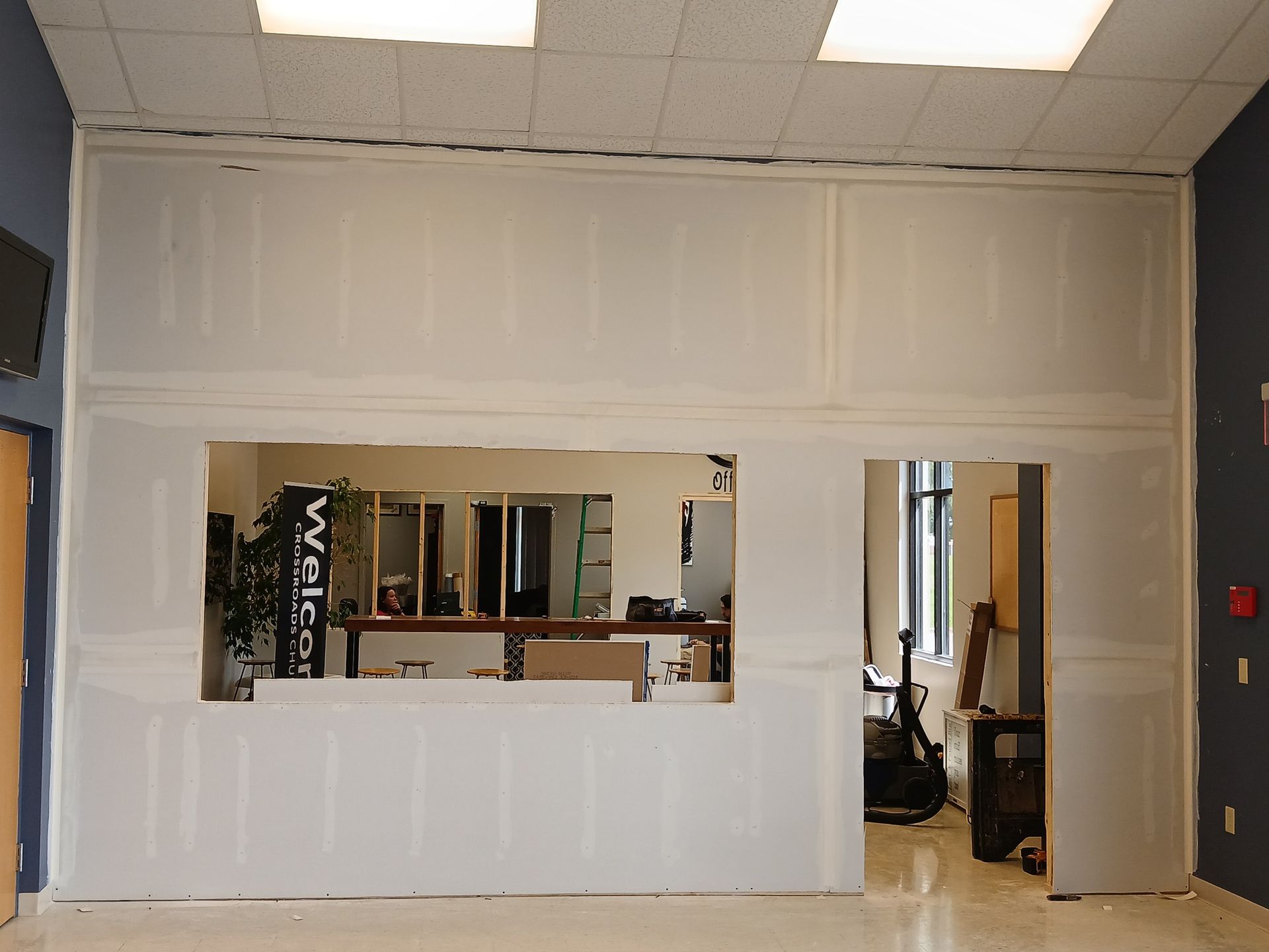White drywall construction with a large opening, inside a building.