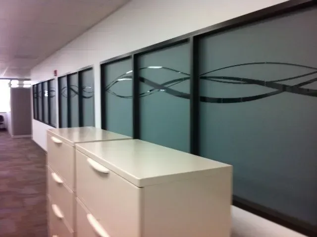 Office hallway with frosted glass windows and cream-colored cabinets along the wall