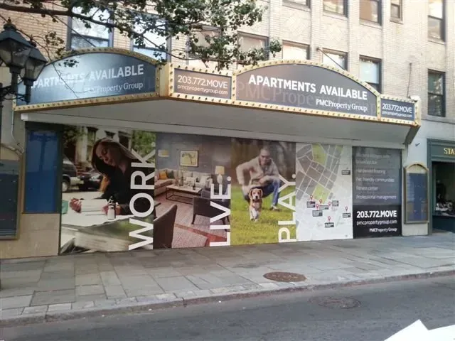 Storefront with apartment rental advertisements and “APARTMENTS AVAILABLE” signage on a city street