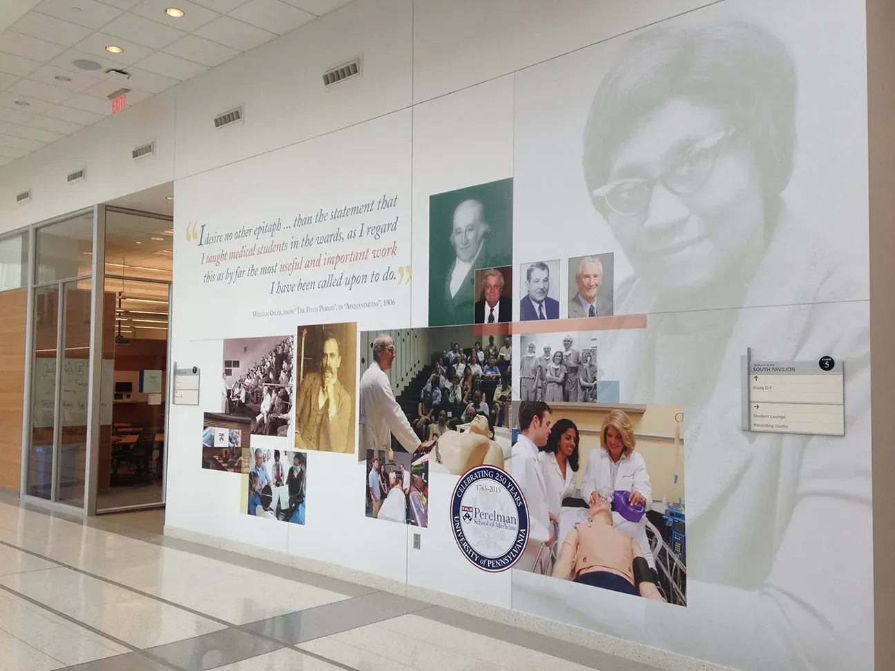 Museum wall with collage photos, portraits, and handwritten notes in a bright hallway