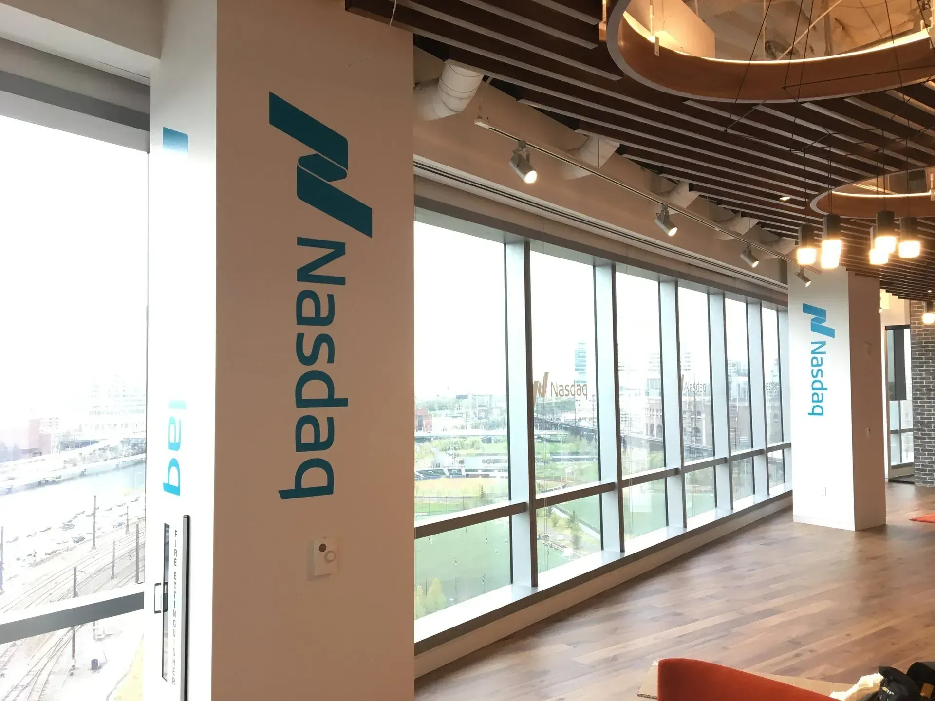 Nasdaq-branded hallway with floor-to-ceiling windows overlooking a city view
