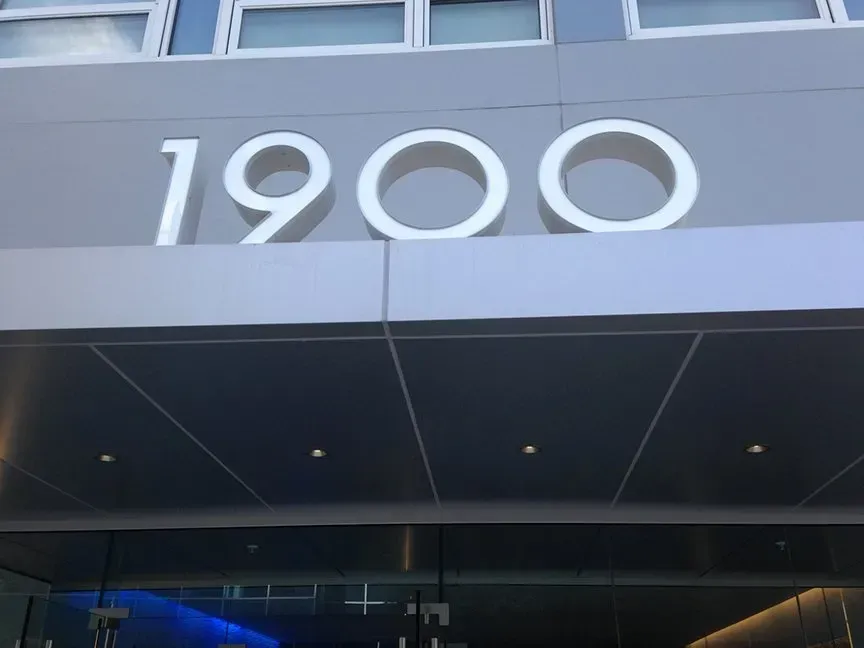 Building facade with large white number “1900” above a dark entrance canopy