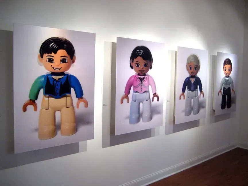 Toy figures displayed on a wall in a row, each with different clothing and hair colors.