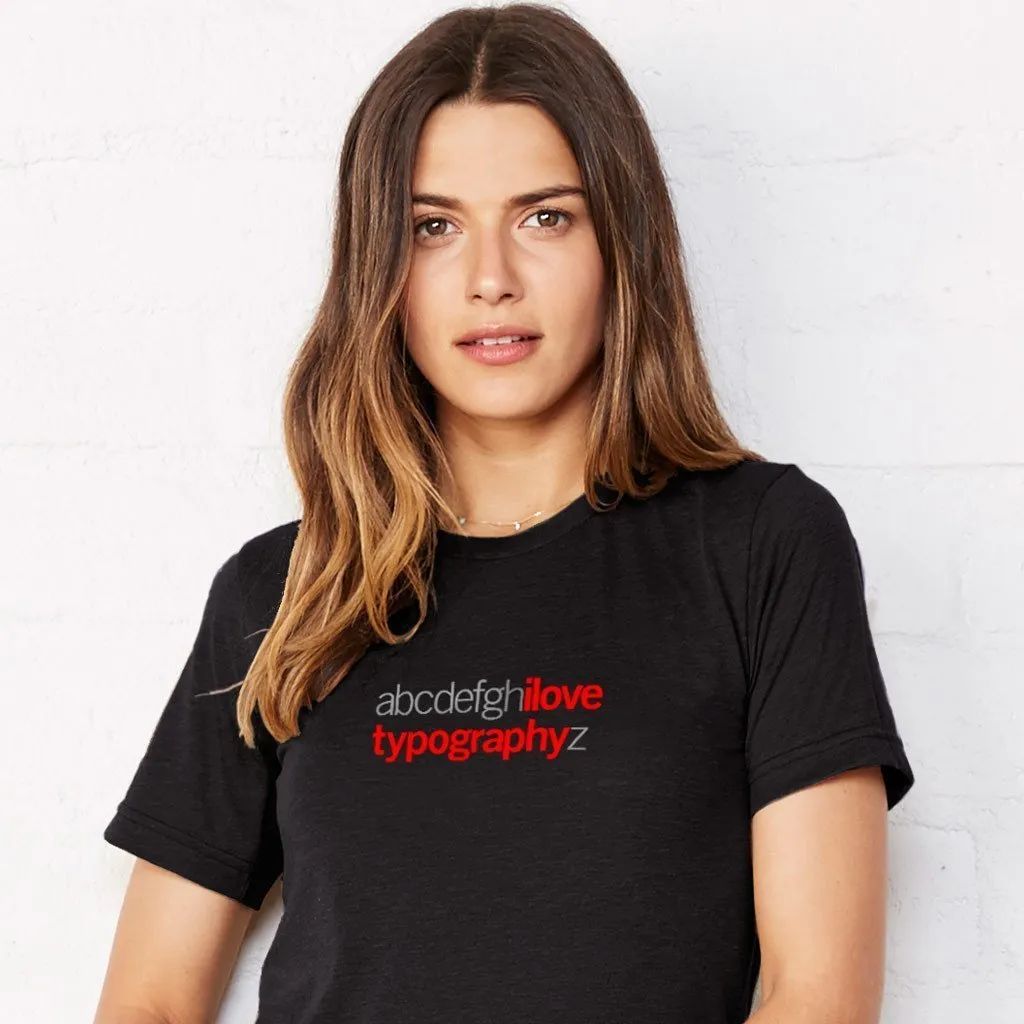 Woman in black T-shirt with red typography text, standing against a white background