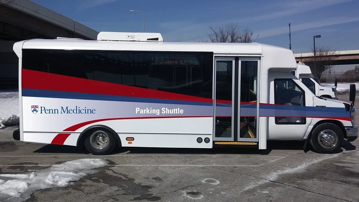 White Rio Metro bus parked on snowy pavement, side view with red and blue stripe and open doors