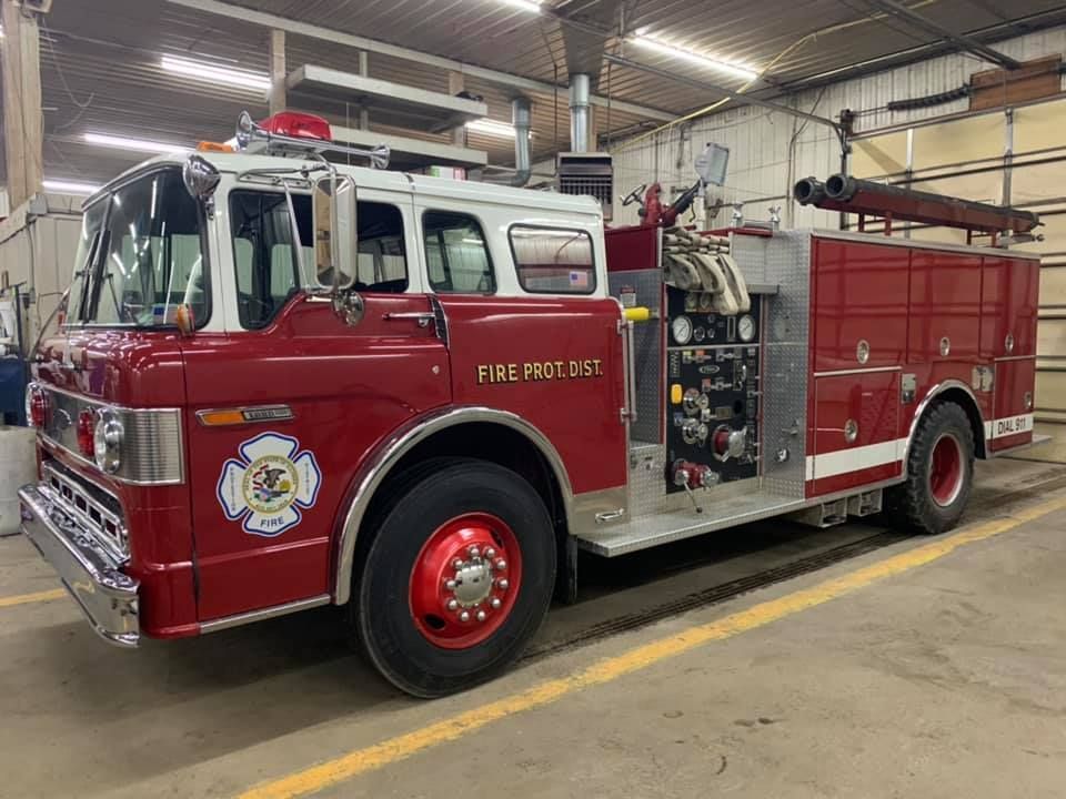 Red and white fire engine parked inside a station.