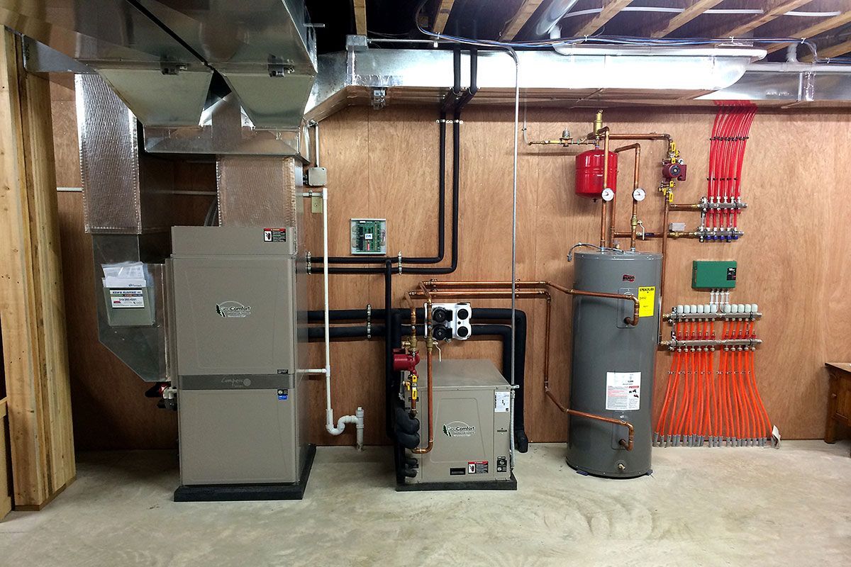 A basement with a heater, water heater, and air conditioner