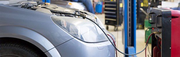 Servicing car air conditioner in auto repair shop