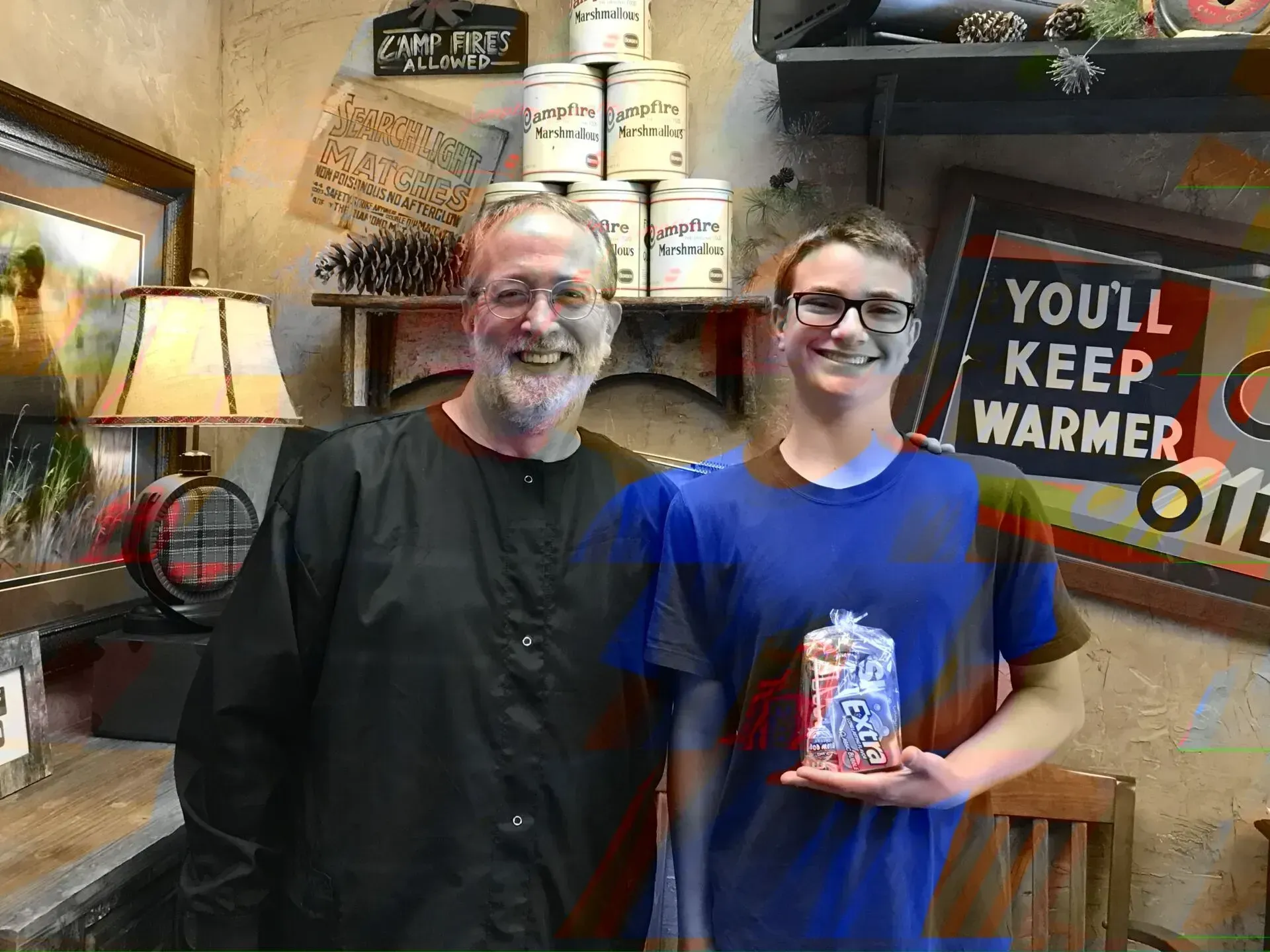 Man and boy in a store setting, smiling and holding an item. Background includes shelves, signs, and cans.