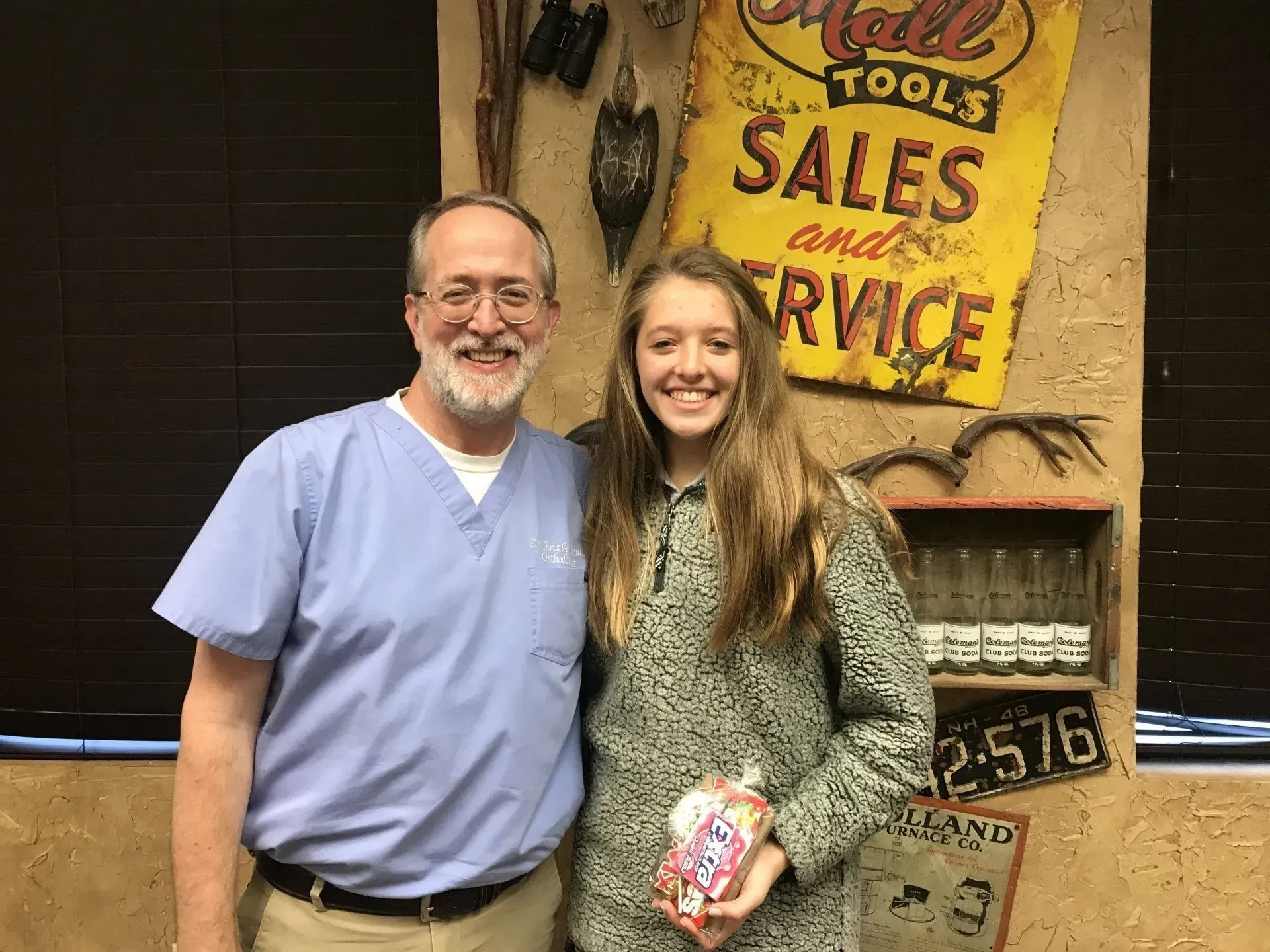 Man in scrubs and smiling person pose together, next to a “Hall Tools” sign.
