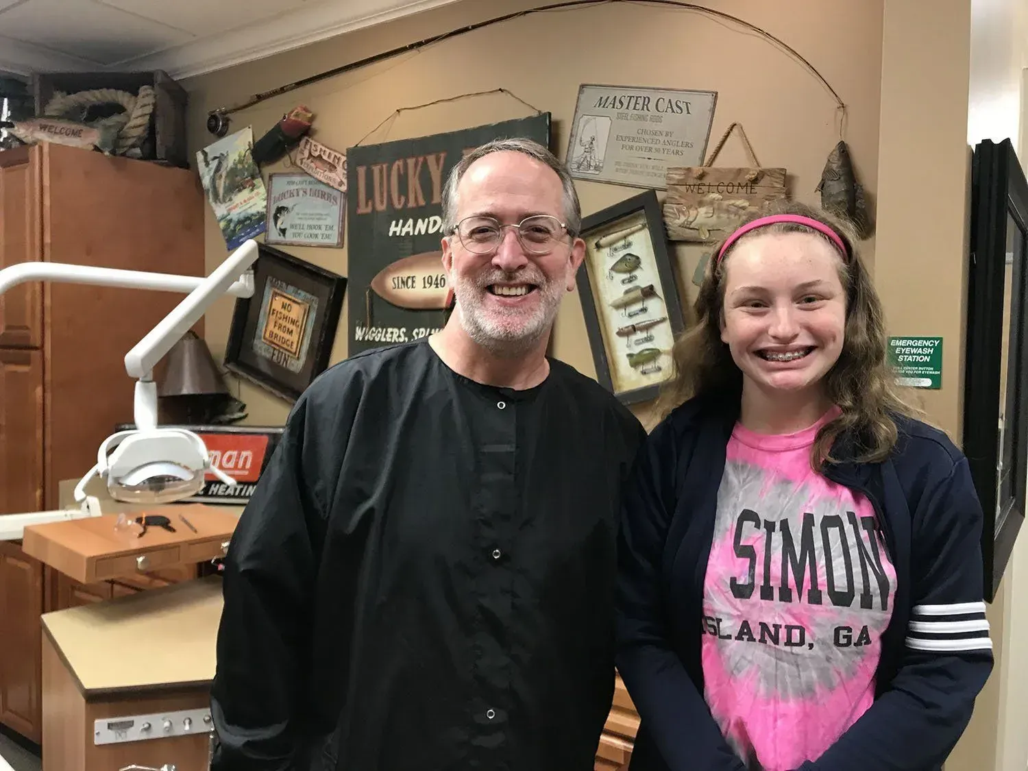 Dentist with a smiling patient in a dental office. The patient is wearing braces.