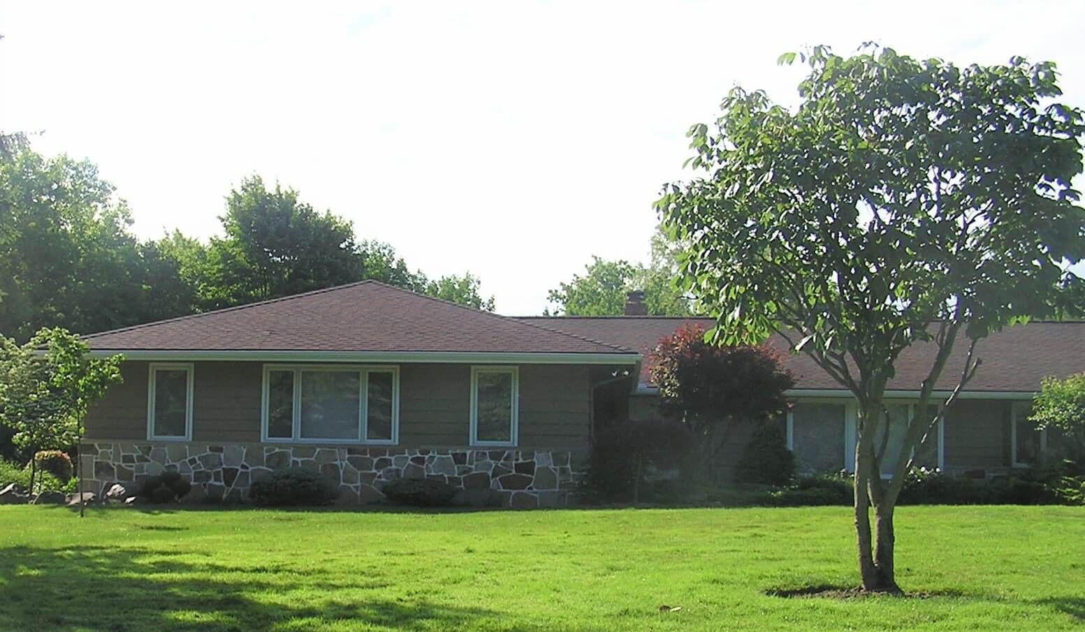 A house with a red roof and a tree in front of it