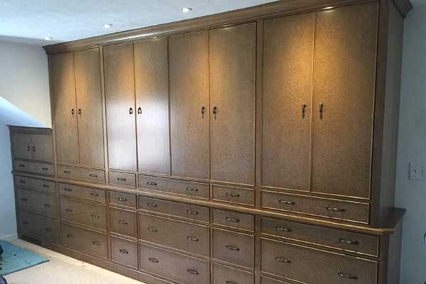 A room with a lot of cabinets and drawers on the wall.