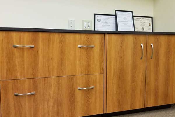 A row of wooden cabinets with certificates on top of them.