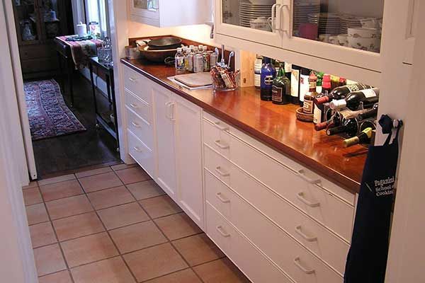 A kitchen with white cabinets and wooden counter tops