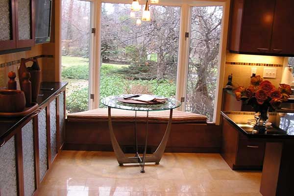 A kitchen with a glass table in front of a window