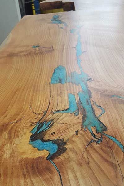 A close up of a wooden table with a river in it.
