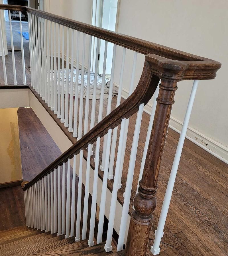 A wooden staircase with white railings and a wooden handrail.
