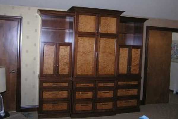 A large wooden cabinet with drawers and shelves in a room