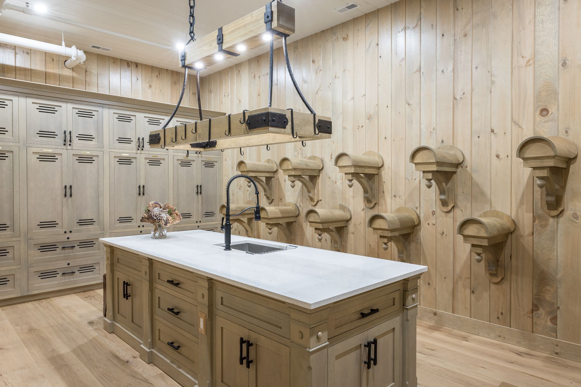 Kitchen with wooden cabinets, island with sink, and hanging light fixture.