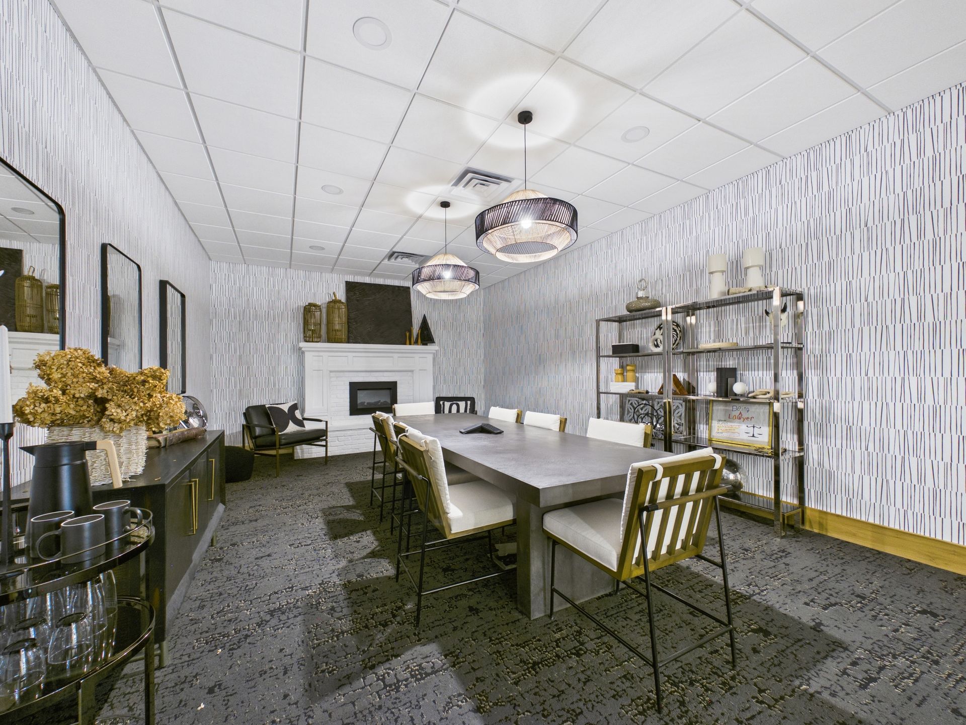 Modern conference room with a long table, white chairs, a fireplace, and patterned wallpaper.
