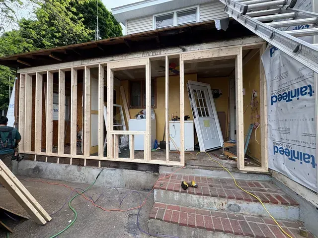 House under renovation with exposed wooden framing and unfinished exterior walls