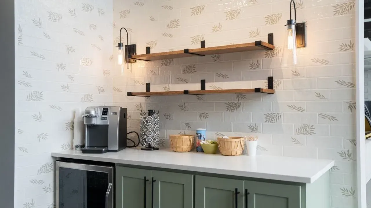 Bright kitchen countertop with coffee maker, jars, and floating shelves on patterned wallpaper