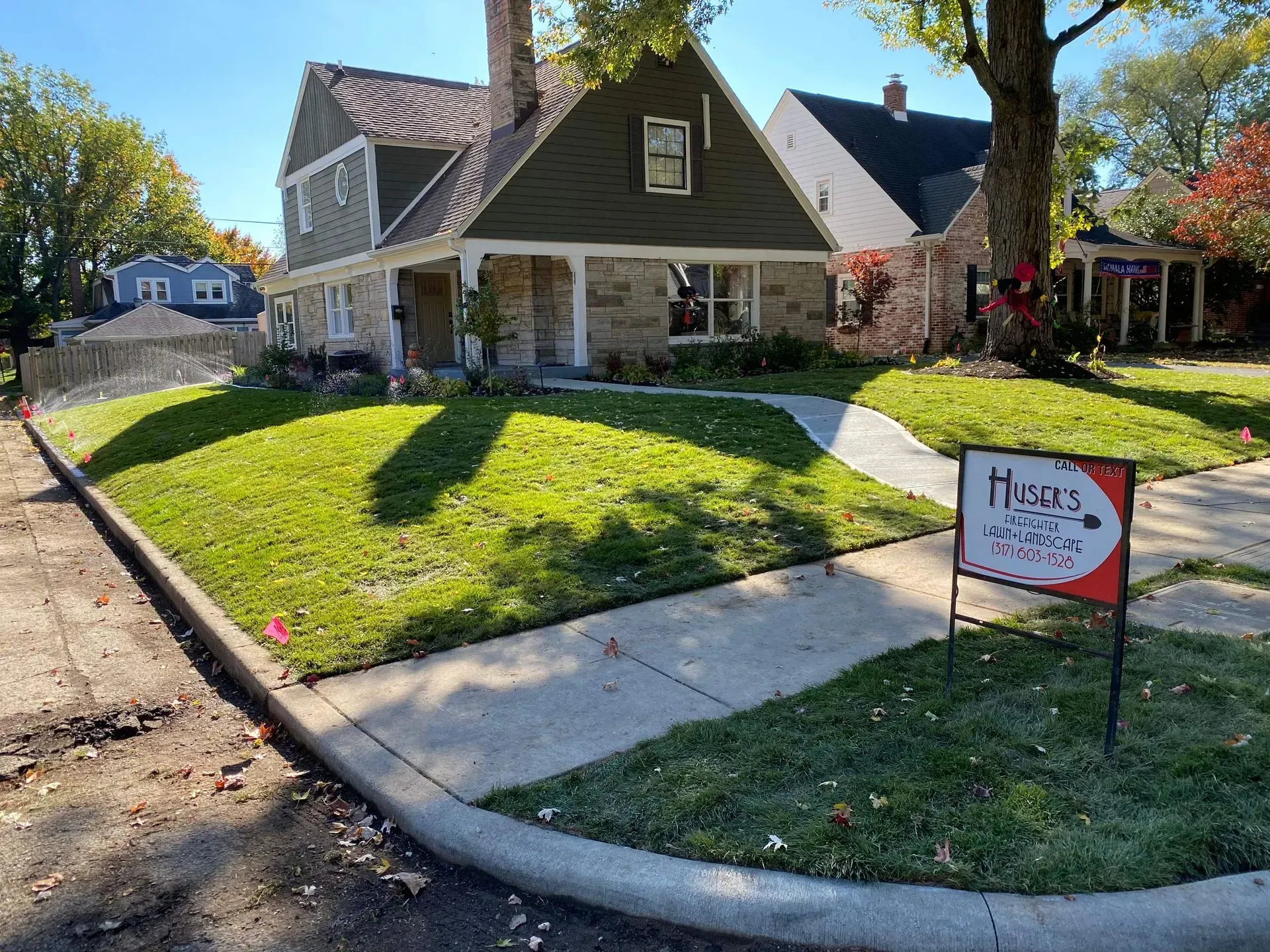 Suburban house with manicured lawn and a red yard sign by the sidewalk