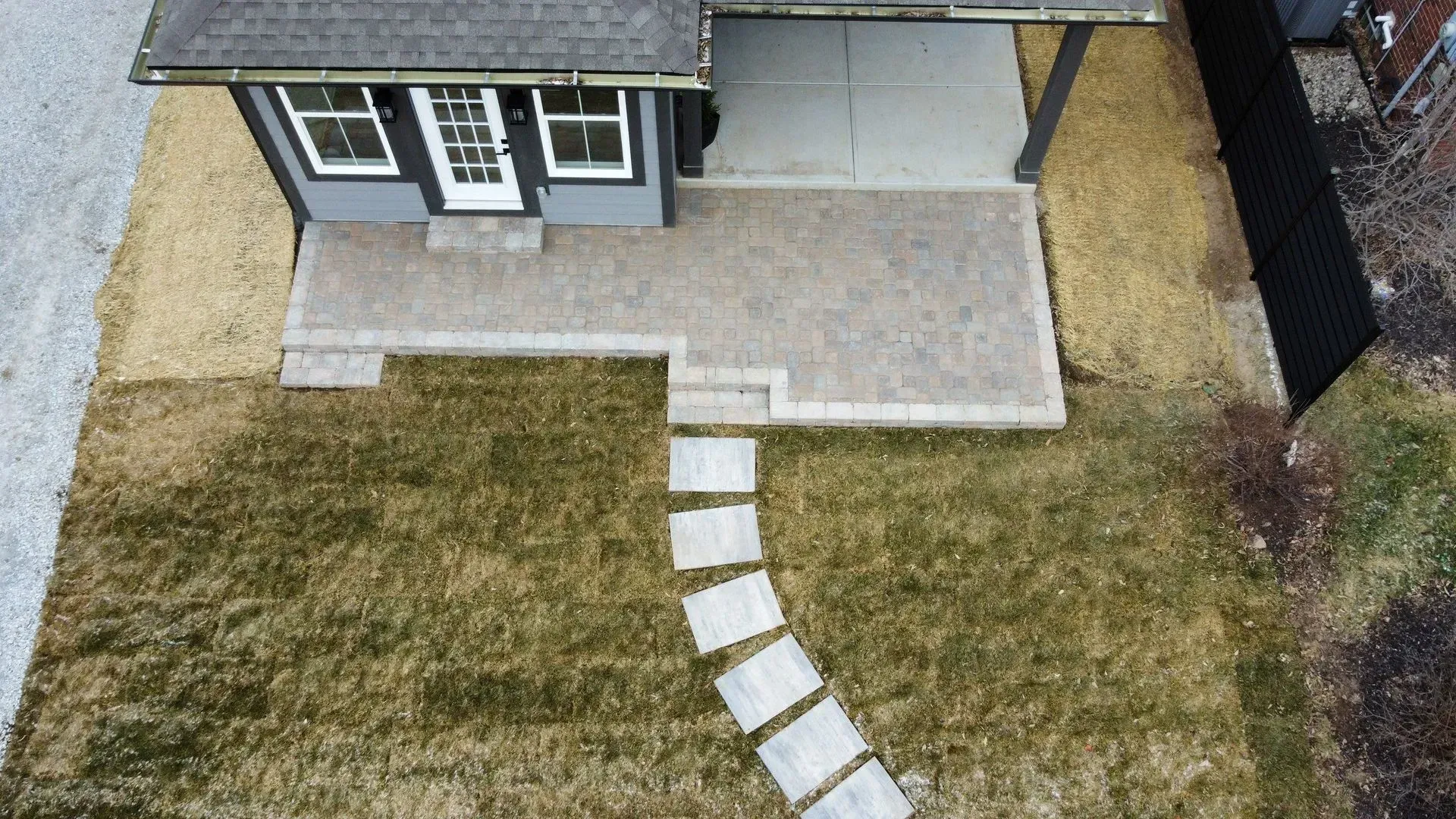 Backyard patio with stepping stone path leading to a small house entrance