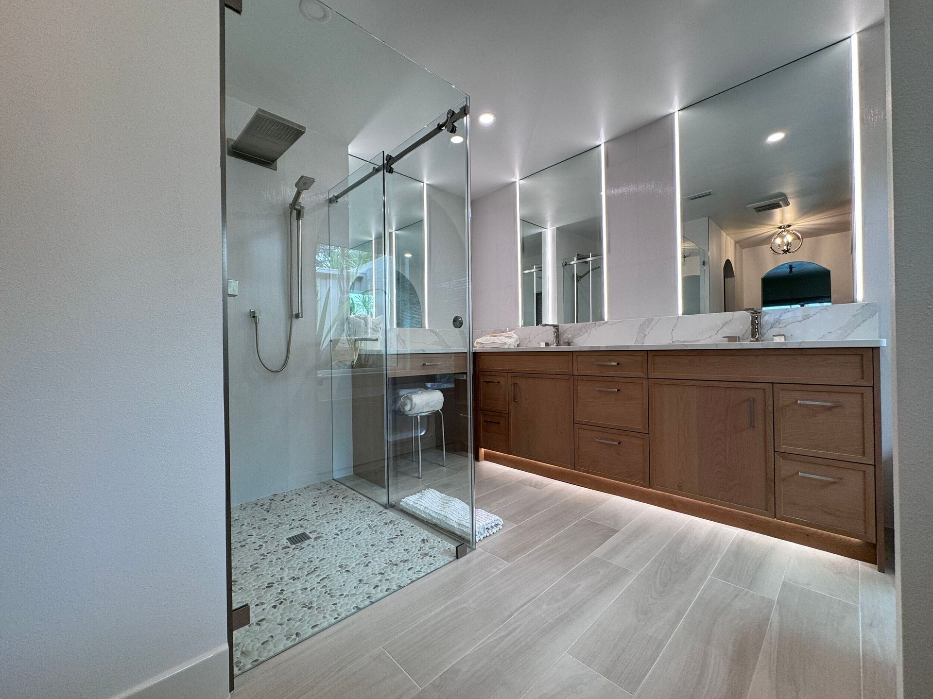A bathroom with a walk-in shower and two sinks.