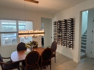 A dining room with a table and chairs, and wine racks on the wall.