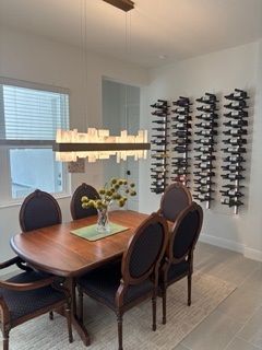 A good-looking dining room with a table and chairs, and a wine rack on the wall.
