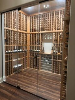Walk-in closet with wood-slat walls, mirrored doors, and warm ceiling lights.