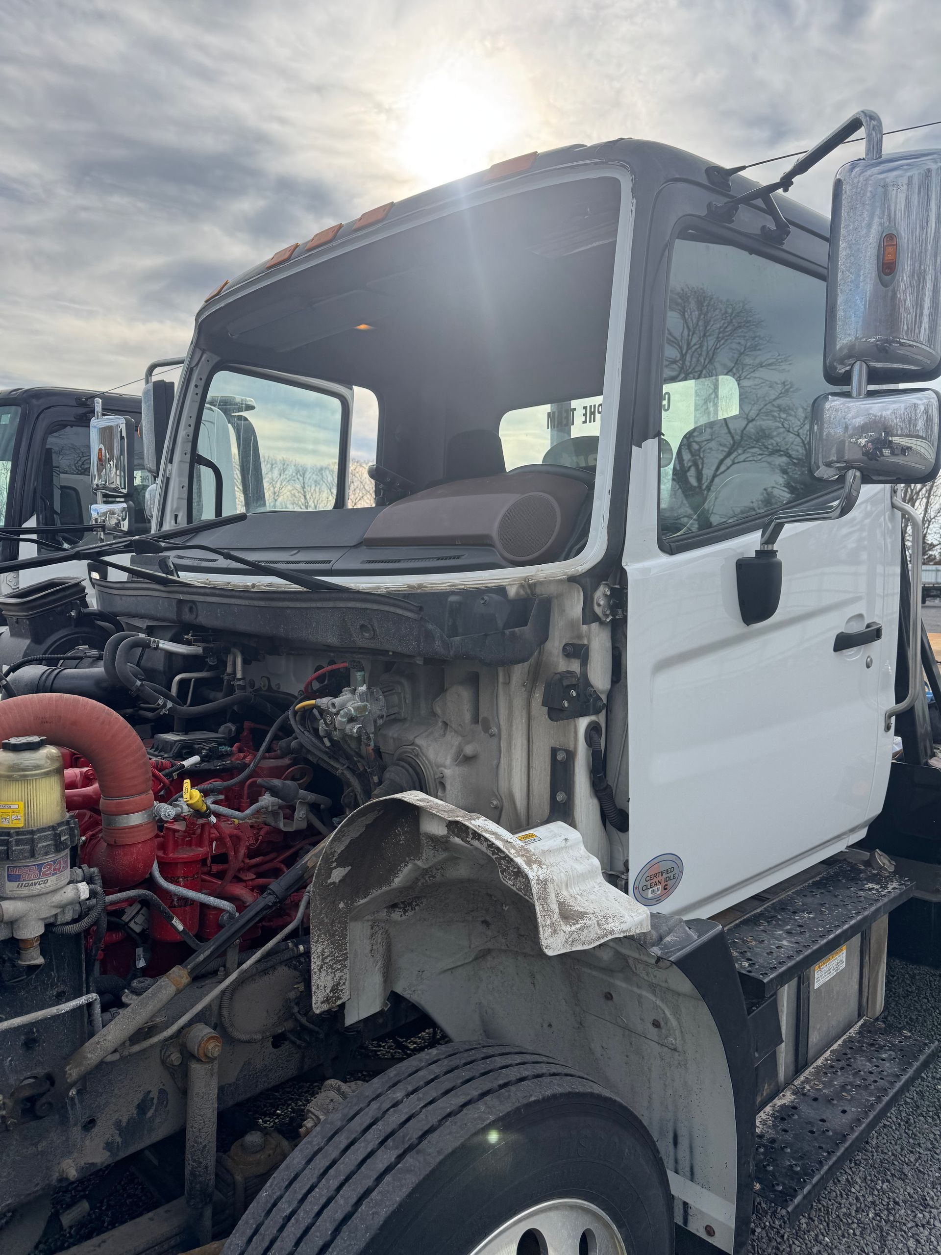 White truck cab with missing front; engine and wheel visible.