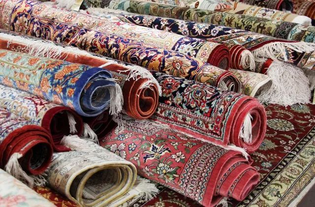 a bunch of rugs are stacked on top of each other on a table