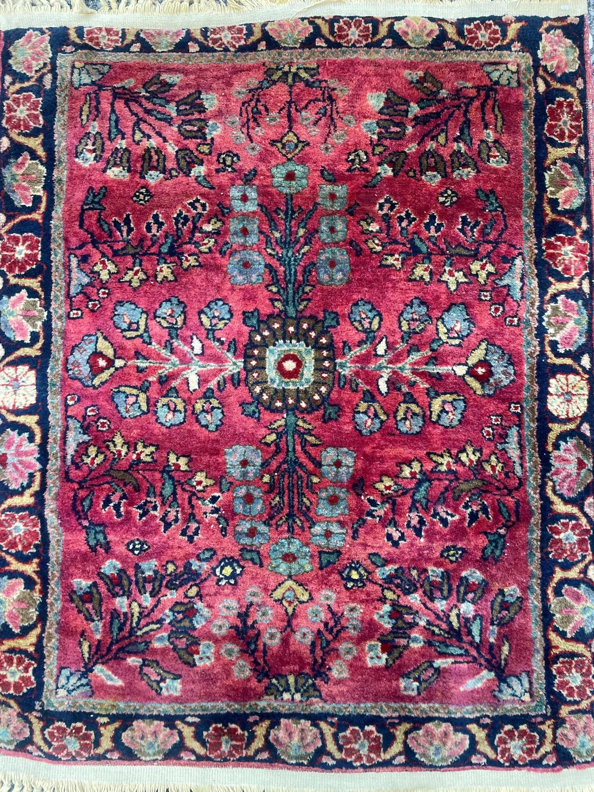a red rug with a floral pattern on it