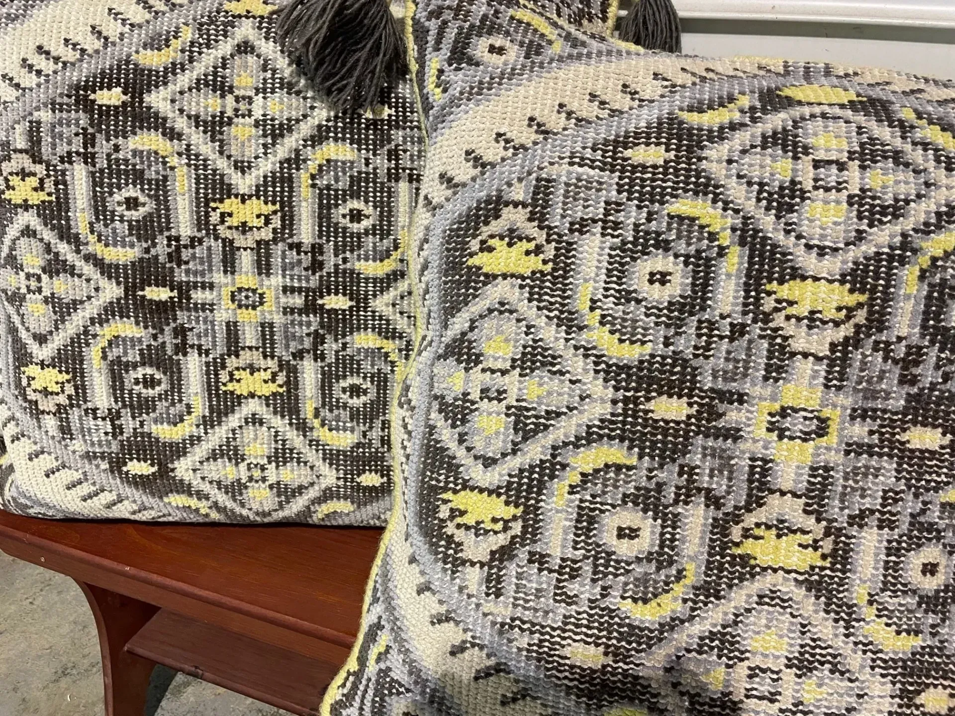 Two pillows are sitting on a wooden table.