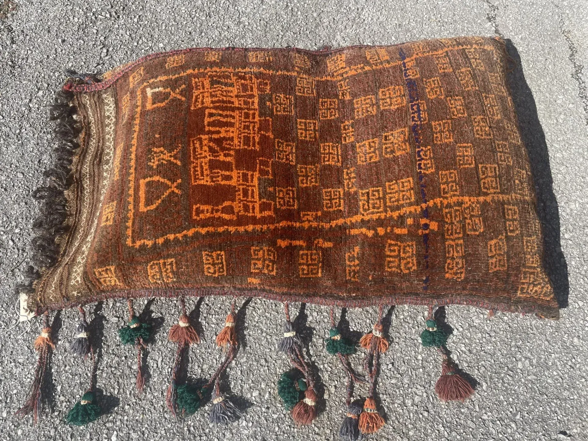 A rug with tassels is sitting on the ground.