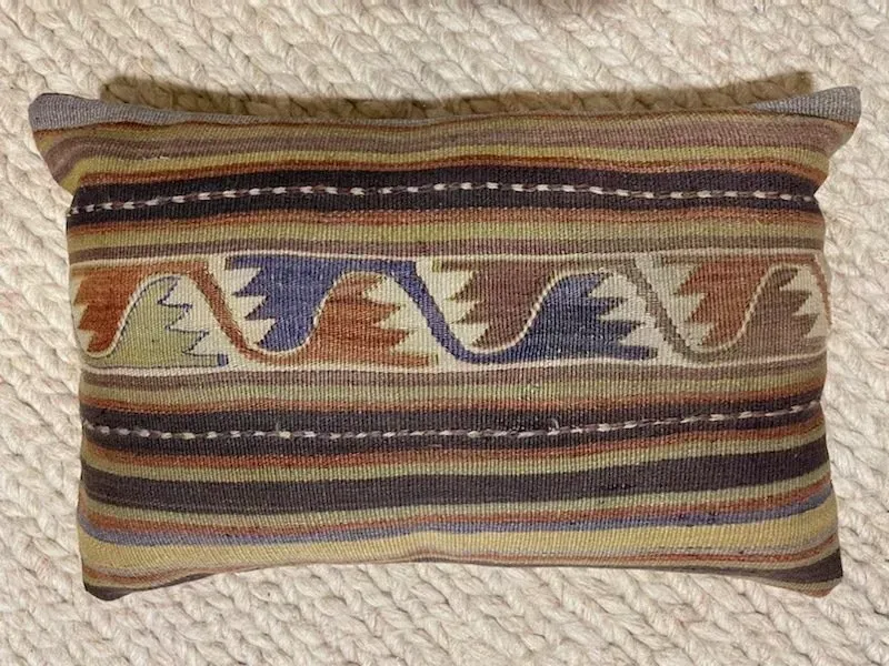 A striped pillow with the word always on it.