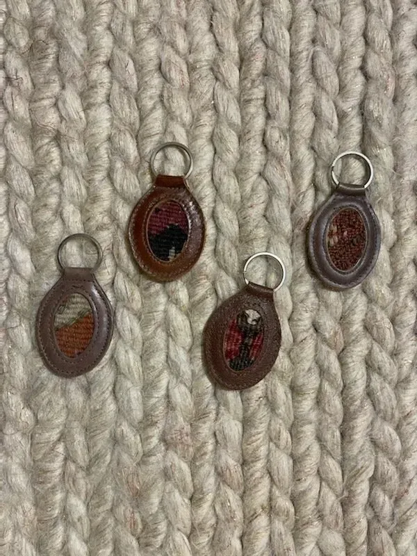 A group of keychains are sitting on top of a knitted rug.