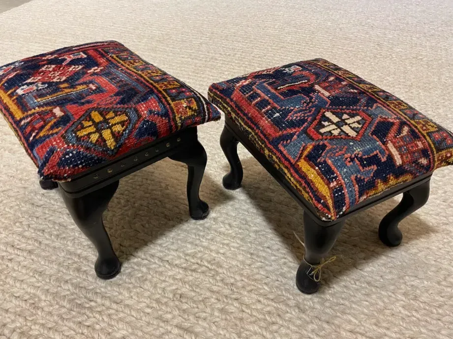 Two colorful ottomans are sitting on a white carpet.