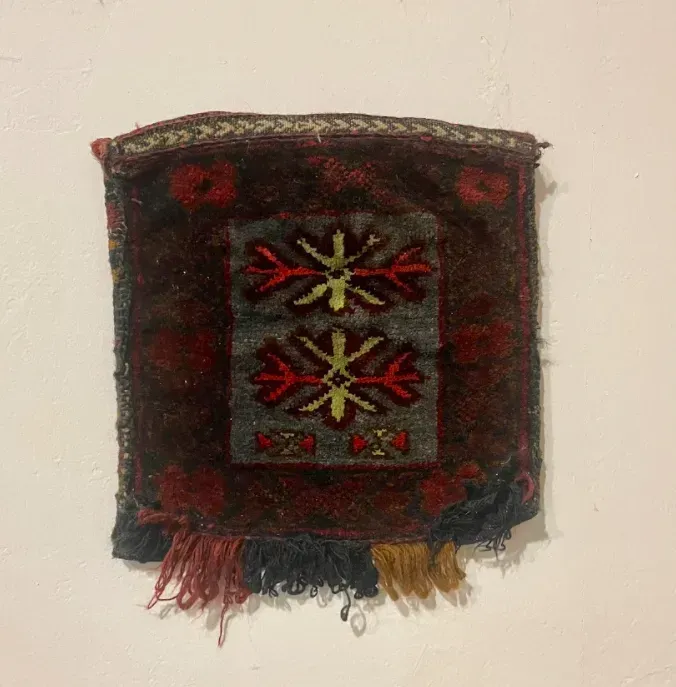 A piece of fabric with a pattern on it is hanging on a wall.