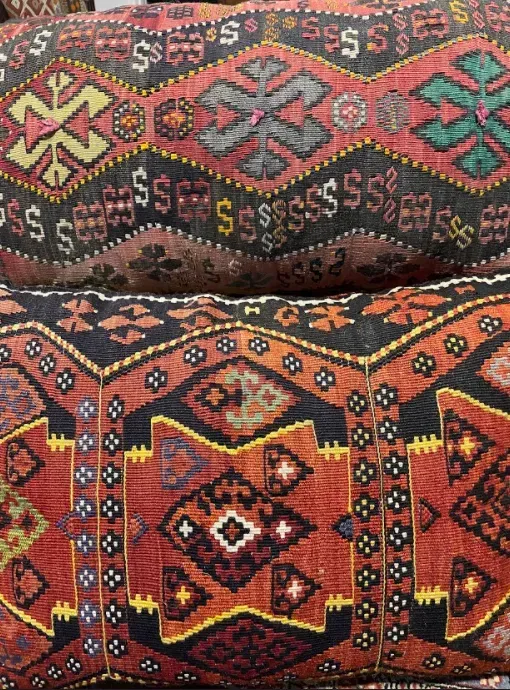 A stack of pillows with a colorful pattern on them.