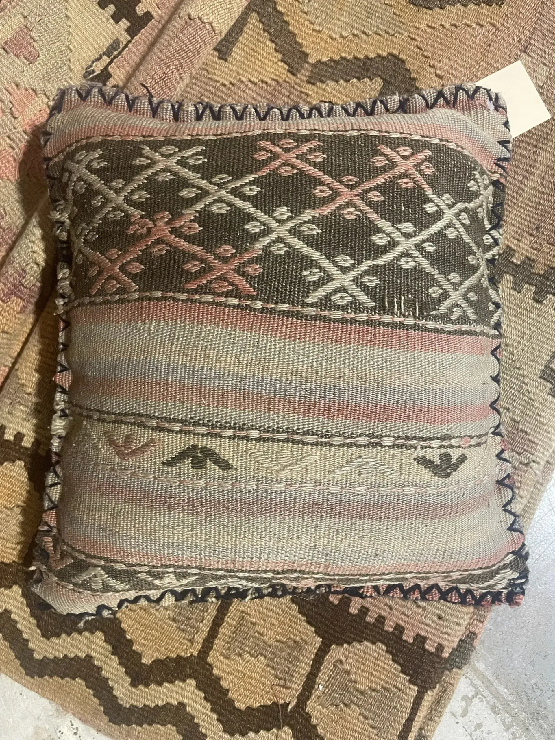 A pillow is sitting on top of a rug on a table.