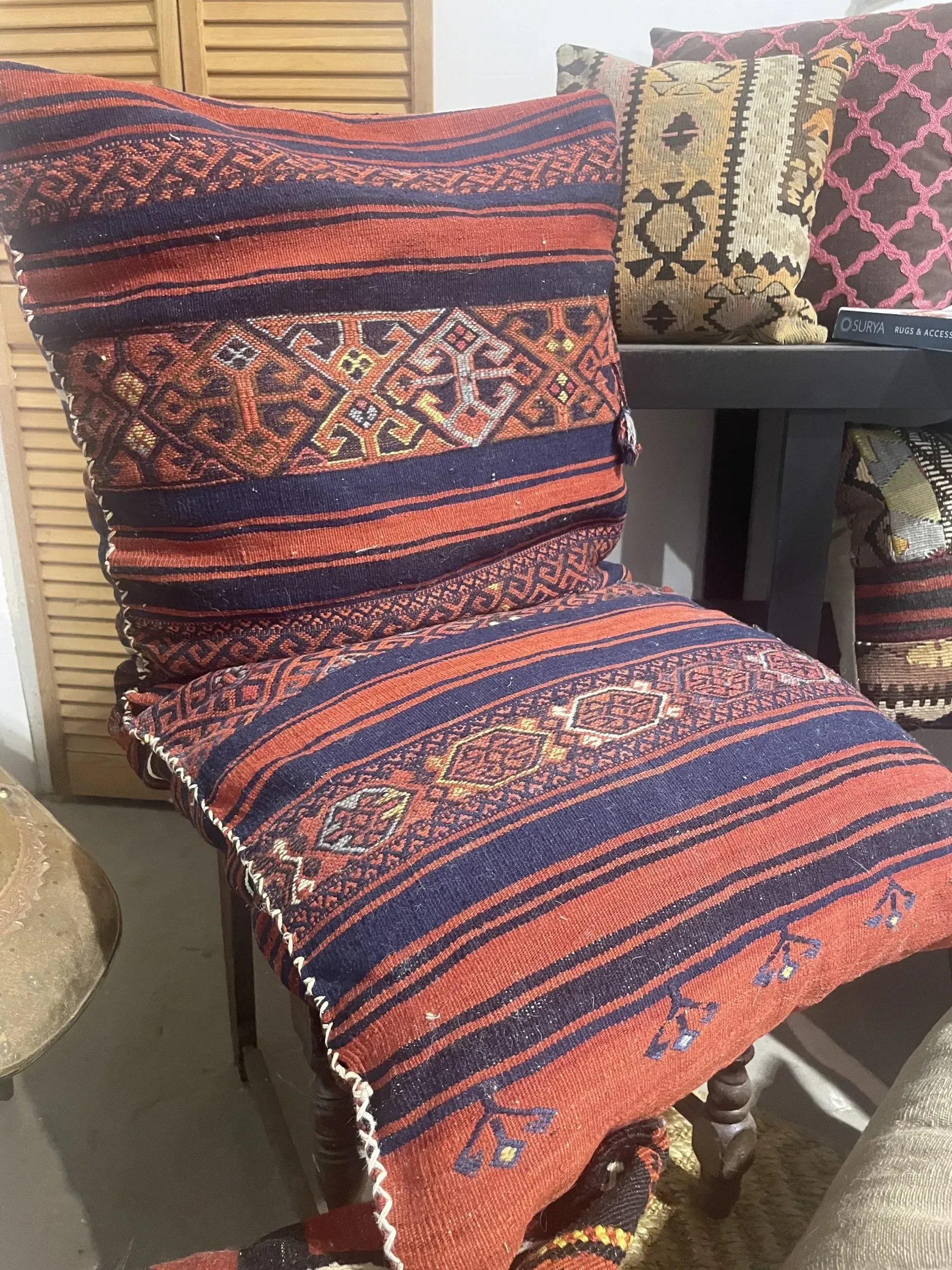 Two colorful pillows are sitting on a chair in a room.