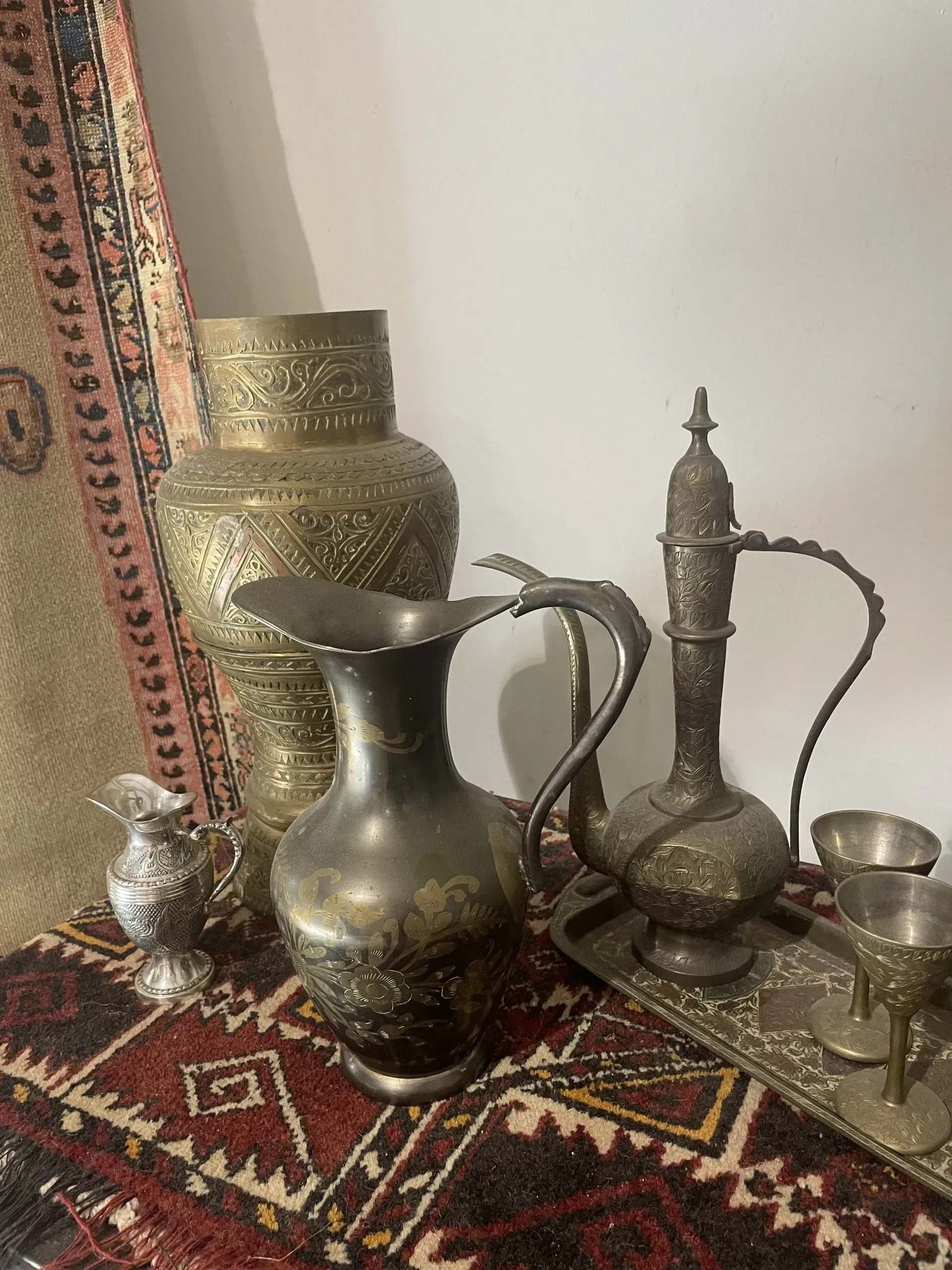 A group of vases and pitchers are sitting on a table.