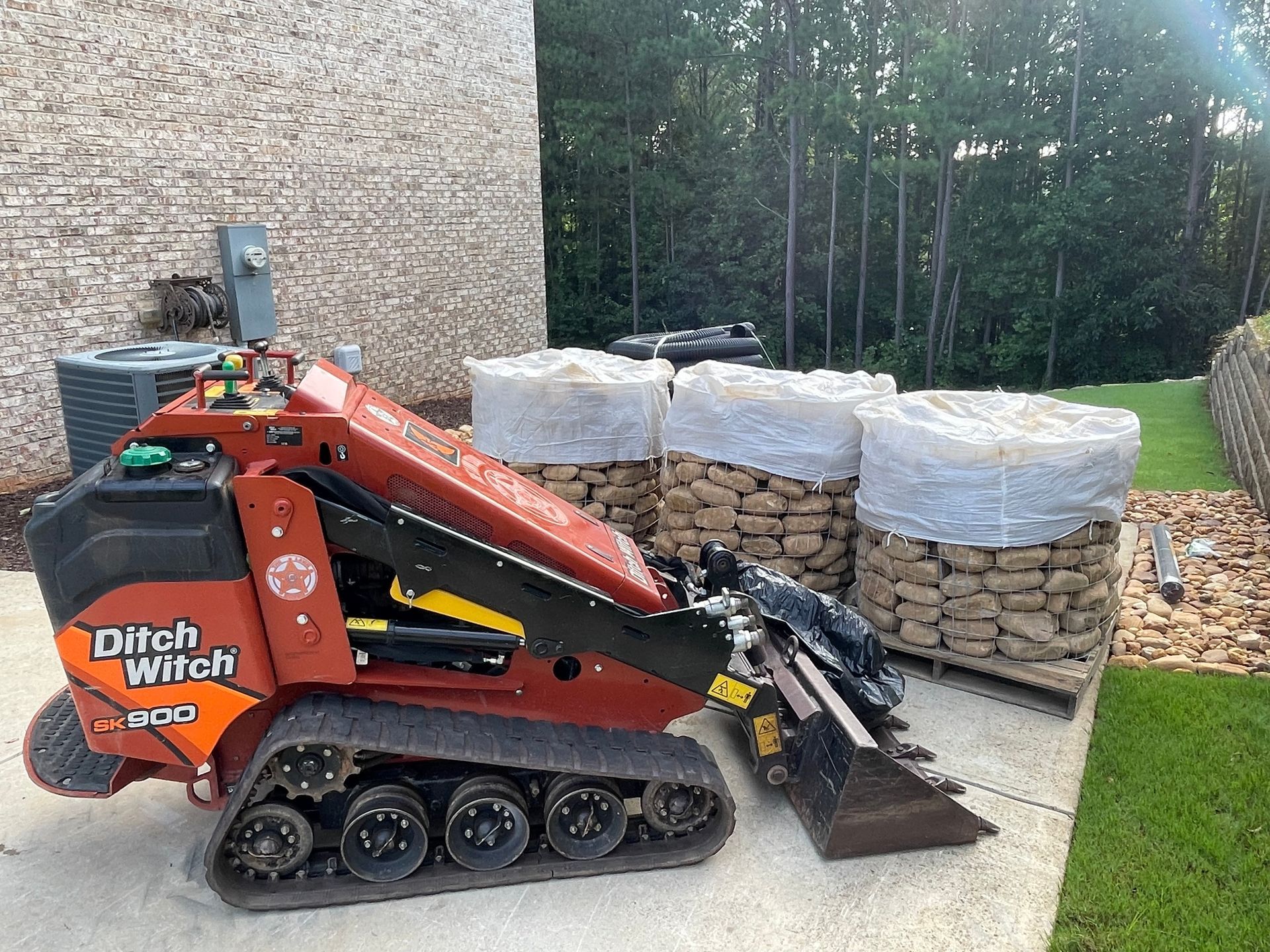 A small tractor is parked in front of a pile of rocks.