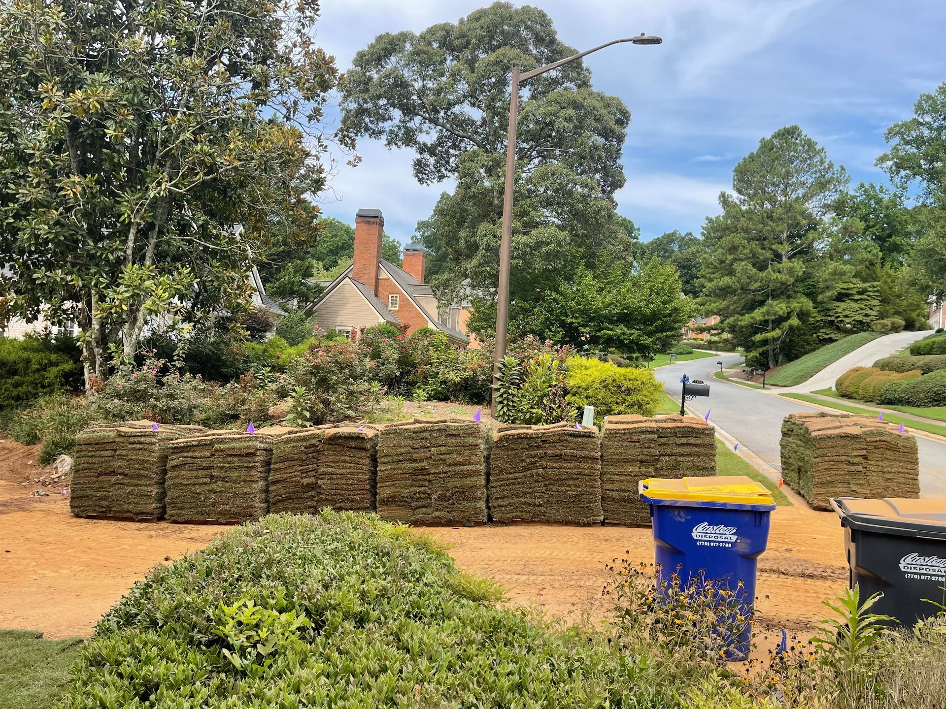 A pile of hay is sitting in front of a house.